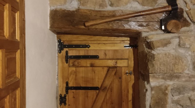 fabricación y colocación de ventanas y puerta en cabaña de piedra